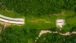 Aerial view of wildlife overpass over highway,  new road with tunnel in green summer mountains.