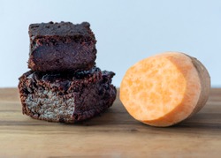 close up plant based vegan chocolate brownies made from sweet potatoes on a plan background for copy space 