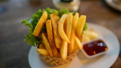 
frenchfried or Potato chips placed on a cylindrical weave container. Served with tomato sauce and mayonnaise