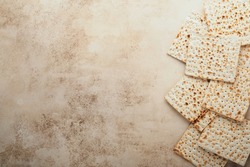 Passover celebration concept. Matzah, red kosher and walnut. Traditional ritual Jewish bread on sand color old concrete background. Passover food. Pesach Jewish holiday.