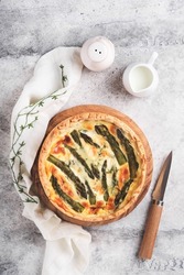 Quiche. Homemade asparagus pie or quiche with cheese, pecorino, bacon and spinach on gray concrete light table background. Asparagus and cheese tart.  French Quiche. Top view.