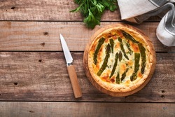 Quiche. Homemade asparagus pie or quiche with cheese and spinach on old wooden table background. Asparagus and cheese tart.  French Quiche. Top view.
