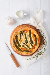 Quiche. Homemade asparagus pie or quiche with cheese and spinach on white wooden table background. Traditional French Quiche. Top view.