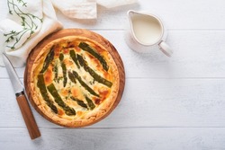 Quiche. Homemade asparagus pie or quiche with cheese and spinach on white wooden table background. Traditional French Quiche. Top view.
