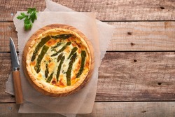 Quiche. Homemade asparagus pie or quiche with cheese and spinach on old wooden table background. Asparagus and cheese tart.  French Quiche. Top view.