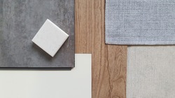 top view of interior finishing material combination containing wooden and concrete vinyl tiles ,white laminate , grey fabric ,grey interior wallpaper and synthesis stone samples.