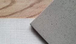close up combination of interior material including grey grained artificial stone or quartz ,grey textile linen fabric wallpaper ,oak wooden vinyl floor tile samples. interior mood tone board.