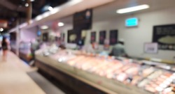 blurred view of fresh fish seafood displayed in iced shelves in supermarket, retail store. raw fish ready for sale in the shopping mall, defocused.
