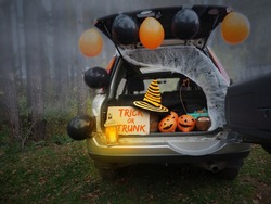 Trick or trunk. Concept celebrating Halloween in trunk of car. New trend celebrating traditional October holiday outdoor. Social distance and safe alternative celebration during coronavirus covid-19
