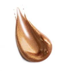 Golden smear of highlighter on white background. Creamy texture of rich shimmery cosmetic product. 