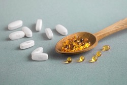 A complex of Mg  and vitamin D ( omega 3 ) capsules for treatment and human health on a light background. Copy space.