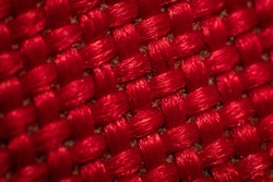 Close-up of synthetic fabric, red fiber. Small gaps between fibers, neat weave, large luster fibers, high magnification, super macro. 