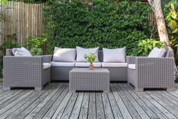 Large terrace patio with rattan garden furniture in the garden on wooden floor.