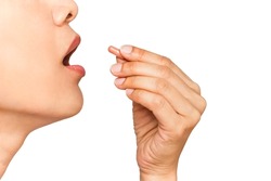 close up image of woman with her mouth open taking vitamin capsule isolate in white background