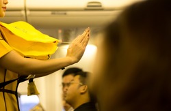 Flight attendant presenting a life vest on board before the flight departure