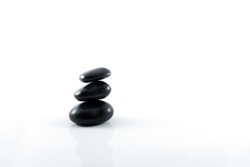 Stack of black pebbles on white background