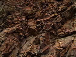     Bright red-brown stone background. Golden rock texture. Mountain close-up.   Mountain texture.                        