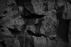    Black stone background. Rock texture. Fragment of the mountain surface. Close-up. Volumetric stone grunge background.                            