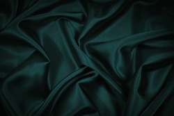  Black blue green abstract background. Dark green silk satin texture background. Beautiful wavy soft folds on the surface of the fabric. Teal elegant background with copy space for design. Web banner.