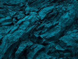     Blue green rock background. Dark turquoise toned mountain surface. Cracked. Close-up. 3d effect. Modern colorful stone background with copy space for your design.                           