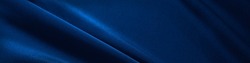    Blue silk satin. Folds in the fabric. Elegant background with copy space for design. Web banner. Website header.                            