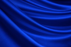   Navy blue silk satin. Wavy soft folds. Shiny fabric surface. Luxury background with copy space for design. Web banner. Birthday, Christmas, Valentine, holiday concept.                               