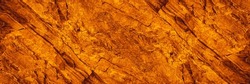 Orange red brown rock texture with cracks. Rough mountain surface. Close-up. Stone background for design. Crushed, broken, crumbled. Web banner. Wide. Panoramic.	