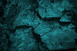 Blue green rock texture. Toned cracked crumbled rough mountain surface. Close-up. Dark teal color. Colorful background for design. Fantasy, fantastic, mystic.