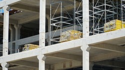 Construction of a multi-storey concrete monolithic building. Many support and load-bearing beams and pillars on one of the levels. Construction site without anyone.bearing pillars of the building.