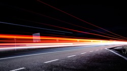 Three red lines / red light trails at night on the road