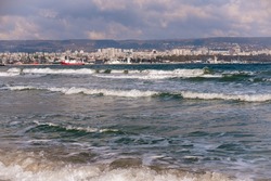 Sea waves against the backdrop of a panoramic view of the center of Varna, Bulgaria.