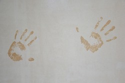 On the gray, plastered wall, there were prints of two hands. Wet hand marks on the gray wall. Abstract grunge handprint on the wall.