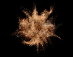 Explosion of brown powder on black background.