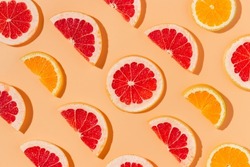 Citrus fruits slices with harsh shadows background. Grapefruit and orange slices, vitamin, summer minimal background