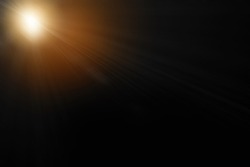Abstract sun flare over black background. lens flare effect Golden sun light.

