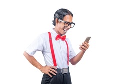 Asian nerd with an ugly face holding mobile phone isolated over white background