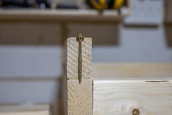 metal coach bolt positioned to test gauge and depth against a sawn timber lumber section