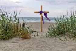 Easter celebration on the beach with cross and purple cloth