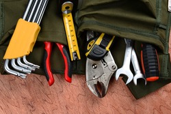 Work tools in bag on wood background.