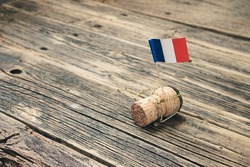 Champagne bottle cork with French flag on an old wooden table, Bastille Day and French National Day 14 July concept