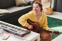 Cheerful Girl With Down Syndrome Playing Guitar
