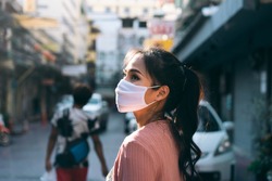 Social distance and new normal lifestyle virus protect at outdoor area concept. Asian adult woman tan skin wear mask on face. Background chinatown landmark destination. Bangkok, Thailand.