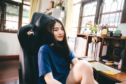 Stay at home office lifestyle concept. Happy smile young adult freelance streamer asian woman wear headset in workplace space with window light on day. Still life with modern digital online media.