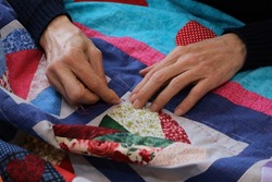 the hand of the patchwork woman and colorful fabrics