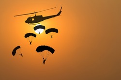 Parachuting exit from a helicopter at sunset.