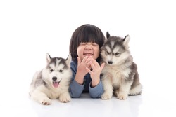 Cute asian child and siberian husky puppies lying on whitebackground,isolated
