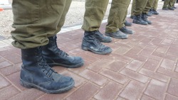 Israel Defense Force reserve duty soldiers standing outside, only their feet seen with military boots. IDF, Israeli soldiers stock image.