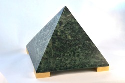 Jade shaped into a pyramid with large gold feet isolated on a white background.  