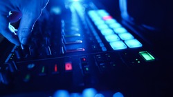Professional DJ Plays a Beat Sampler with Color Drum Pads and Samples in Studio Environment. Beatmaker Plays edm Tracks on Party in a Nightclub. Electronic Musical Instrument.