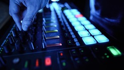 Professional DJ Plays a Beat Sampler with Color Drum Pads and Samples in Studio Environment. Beatmaker Plays edm Tracks on Party in a Nightclub. Electronic Musical Instrument.